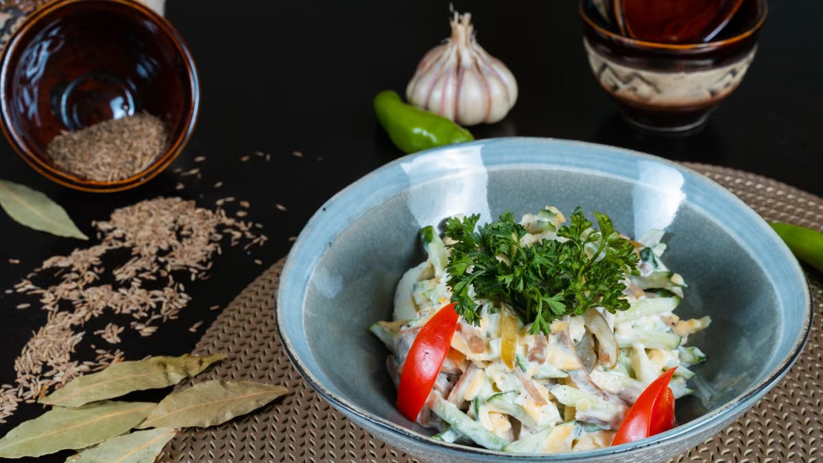 A vibrant salad with fresh vegetables, herbs, and spices, beautifully plated.